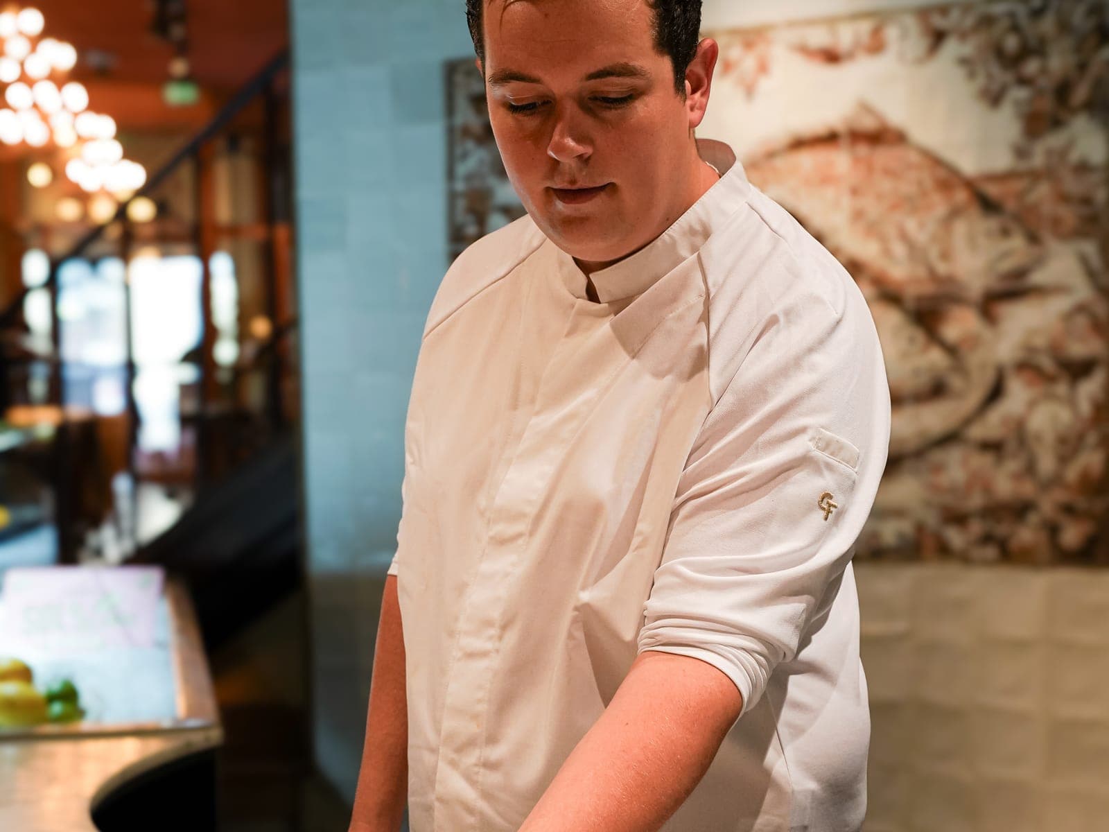 Chef kookt buiten op een vuurschaal aan het water, in Cheffix-kokskleding